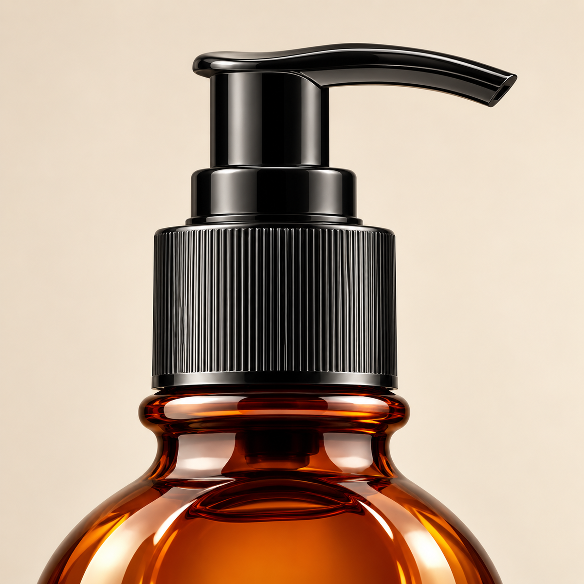 Hair oil bottle pump and amber shoulder detail; label below crop