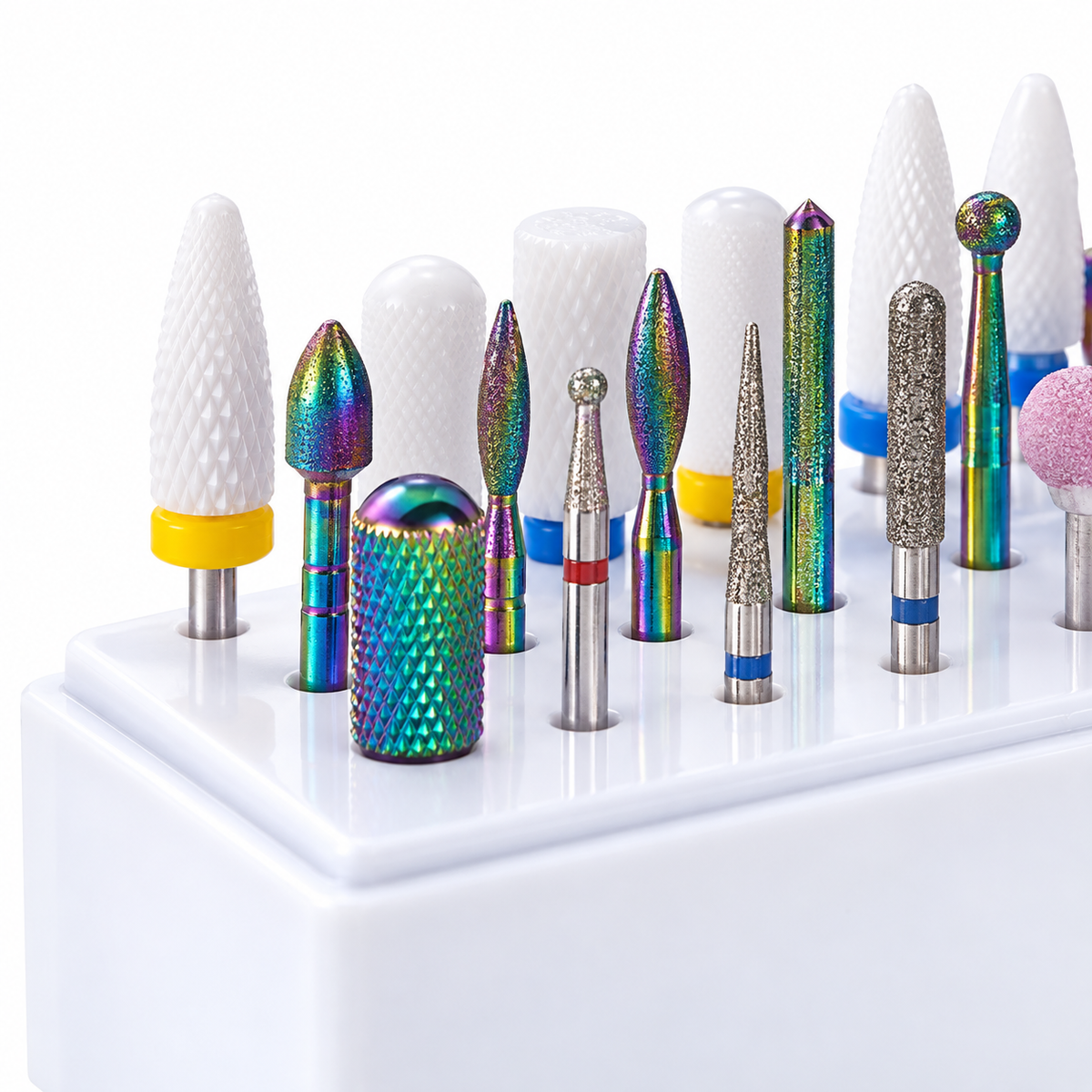 Close-up of assorted ceramic, abrasive and metal nail drill bits in a white holder