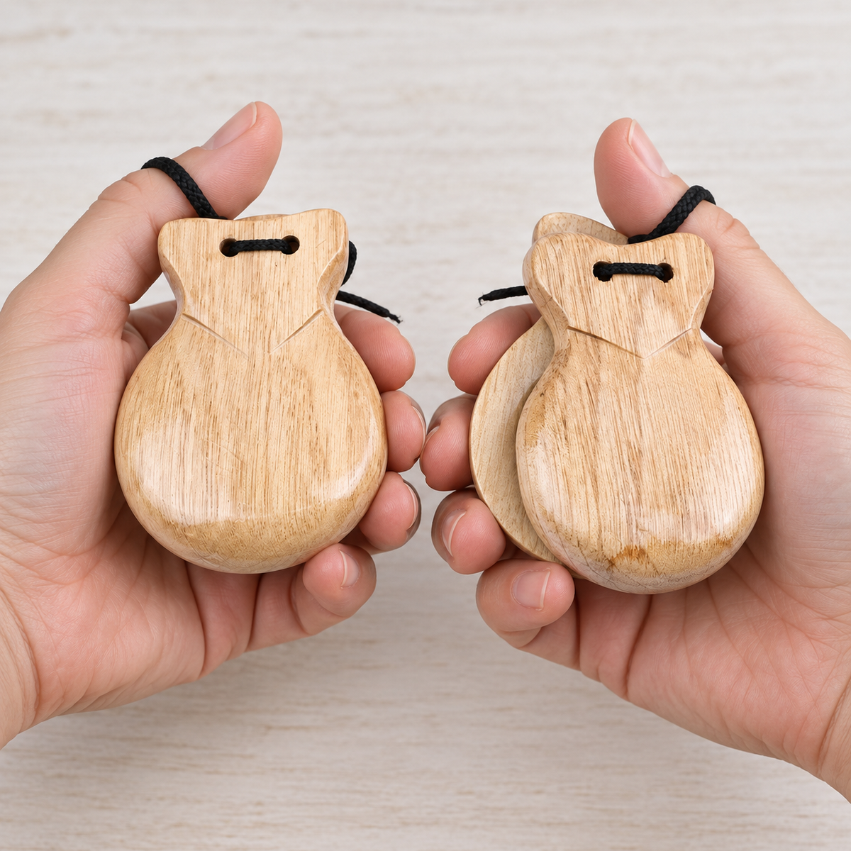 Natural wood castanet pair held in hands