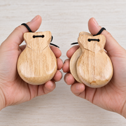 Natural wood castanet pair held in hands