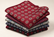 Stack of patterned men's pocket squares with burgundy floral design on top