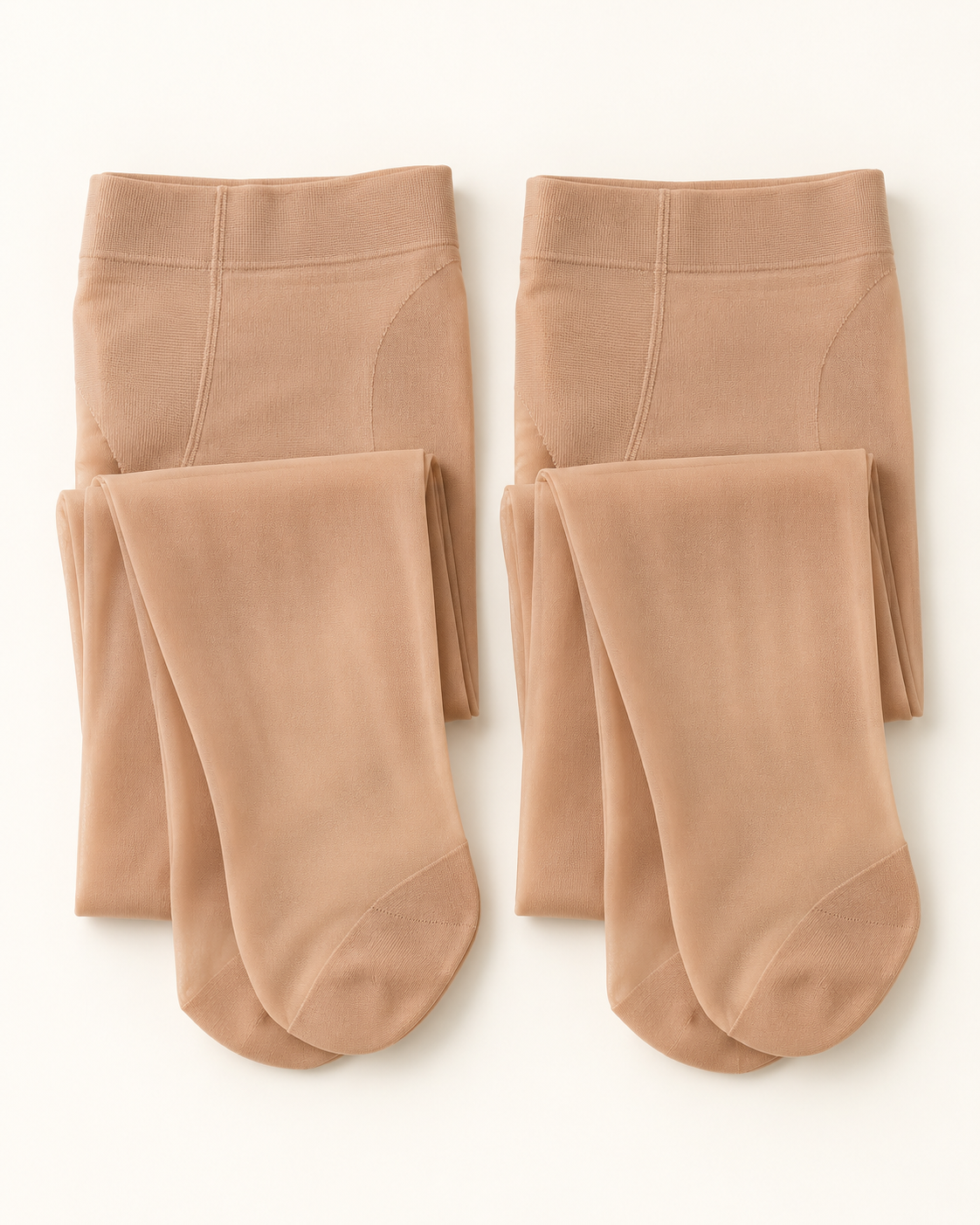 Two pairs of nude control-top sheer pantyhose on warm white