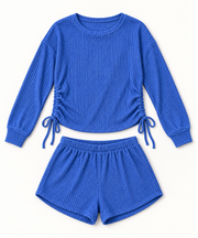 Women's cobalt-blue waffle-knit top and shorts set on a studio background