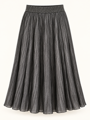 Black metallic pleated midi skirt with studded waistband on a studio background
